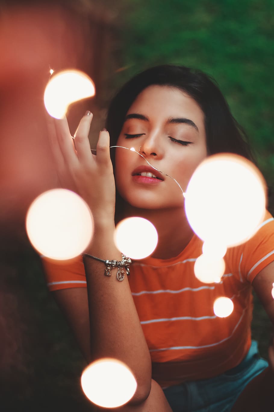 Premium Photo | Happy woman wearing glowing jacket with sequins is holding  light balls in her hands