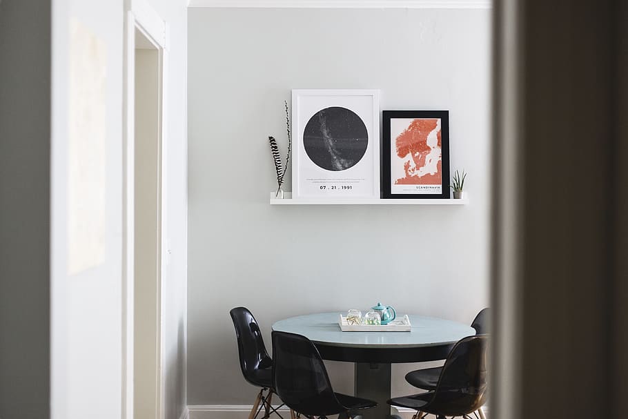 table with four chairs under two posters on wall, room, picture