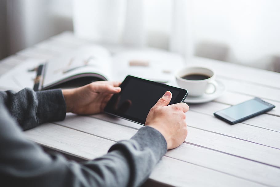 Man holds digital tablet  in his hands, coffee, desk, device HD wallpaper
