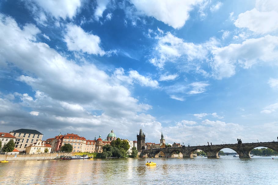 Beautiful day with blue sky and clouds in Prague and a view of the bridge from the river HD wallpaper