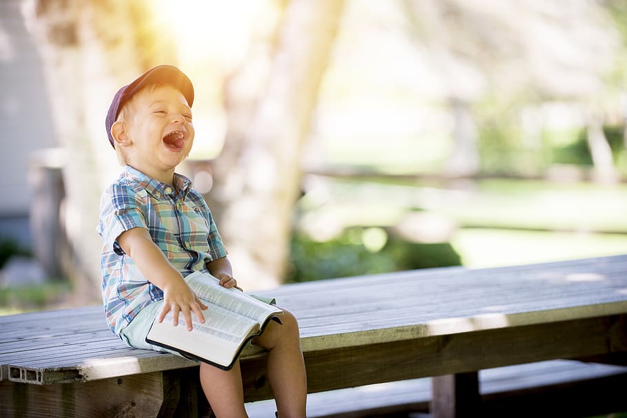 boy sitting on bench while holding a book, childhood, happiness HD wallpaper