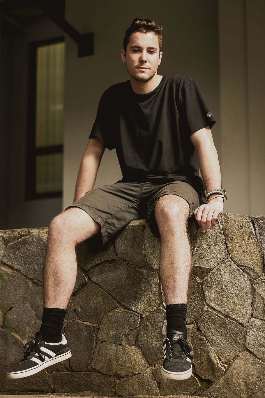 man wearing black crew-neck shirt sitting on concrete floor, person, HD wallpaper