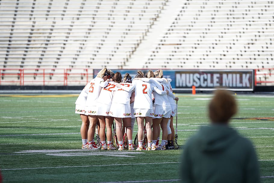 all women lacrosse team on huddle at the field, group of people