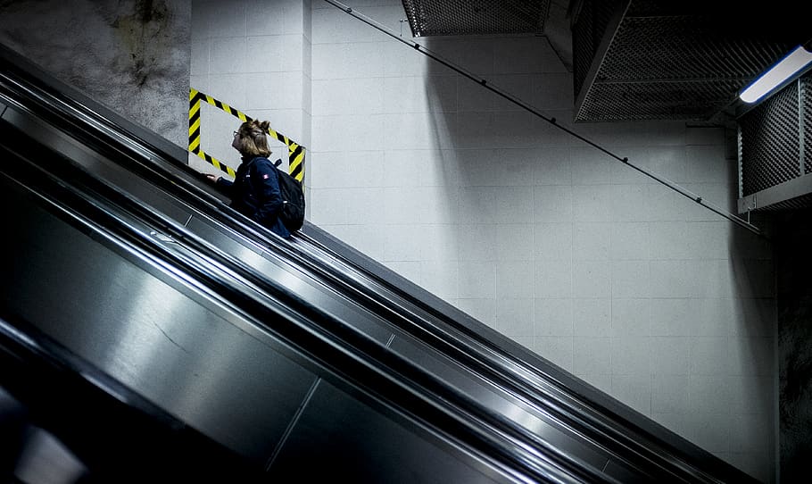 person using escalator inside the building, stockholm, sweden HD wallpaper