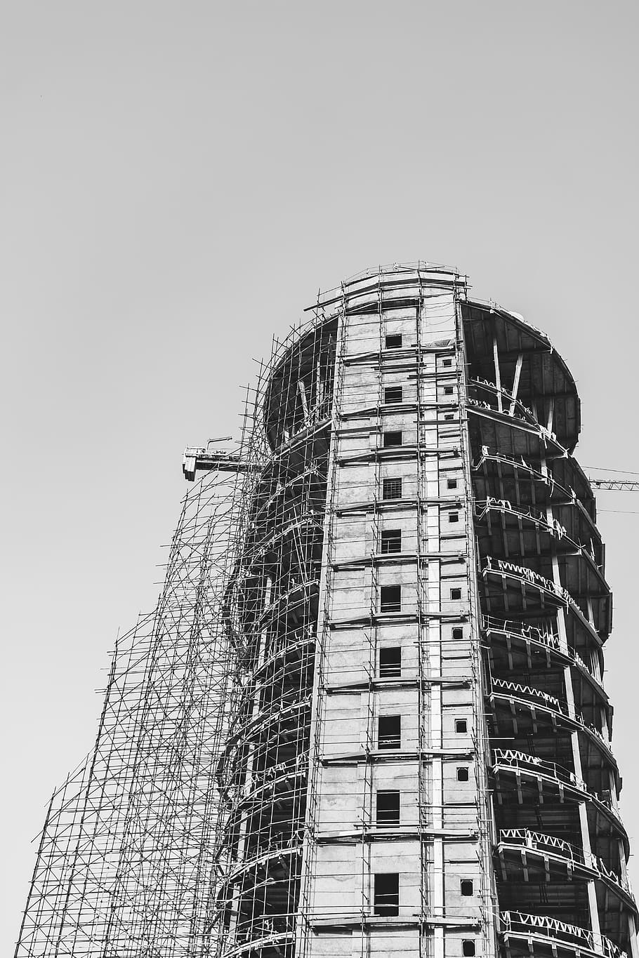 grayscale photo of construction of high-rise building, scaffolding