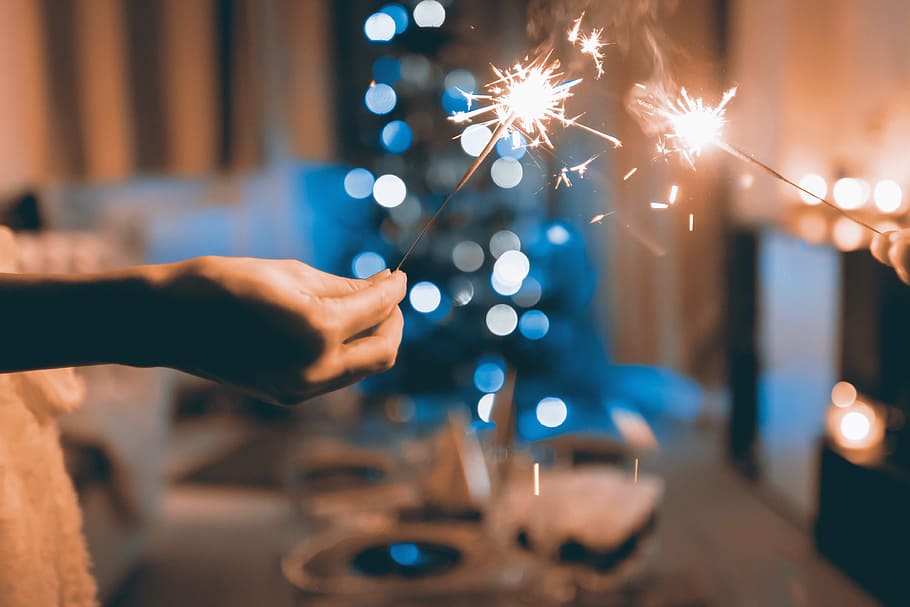Hands of people holding Bengal light at the party, human hand HD wallpaper