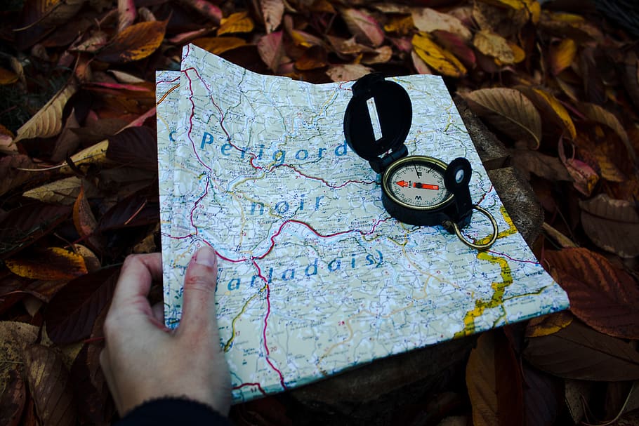 round black compass and white and blue map, guidance, human hand HD wallpaper