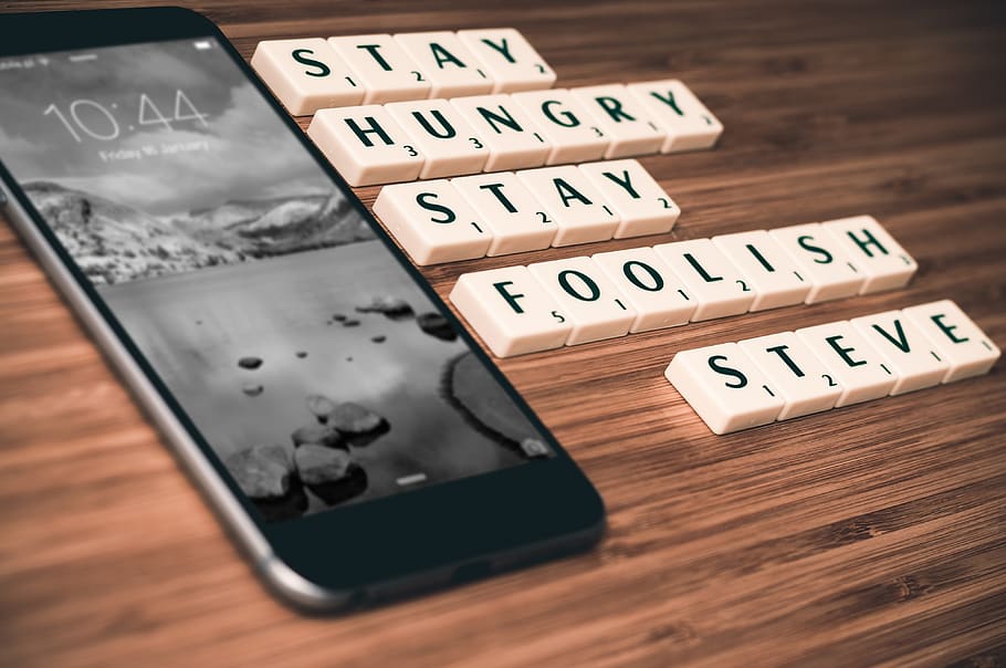 Turned-on Space Gray Iphone 6 Beside Scrabble Chip With Stay Hungry Stay Foolish Steve Text on Table, HD wallpaper