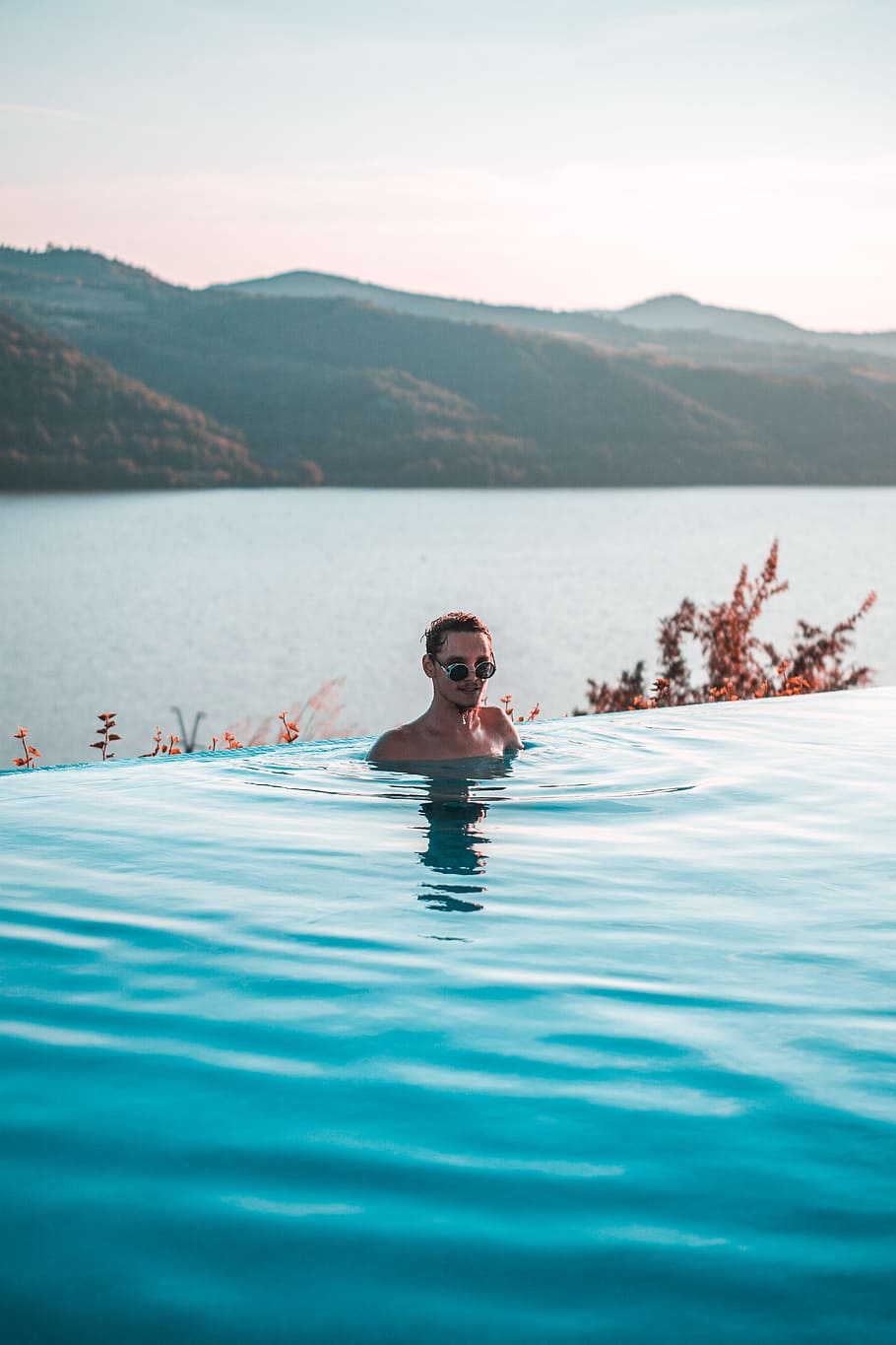man wearing black sunglasses swimming on infinity pool near body of water at daytime, HD wallpaper