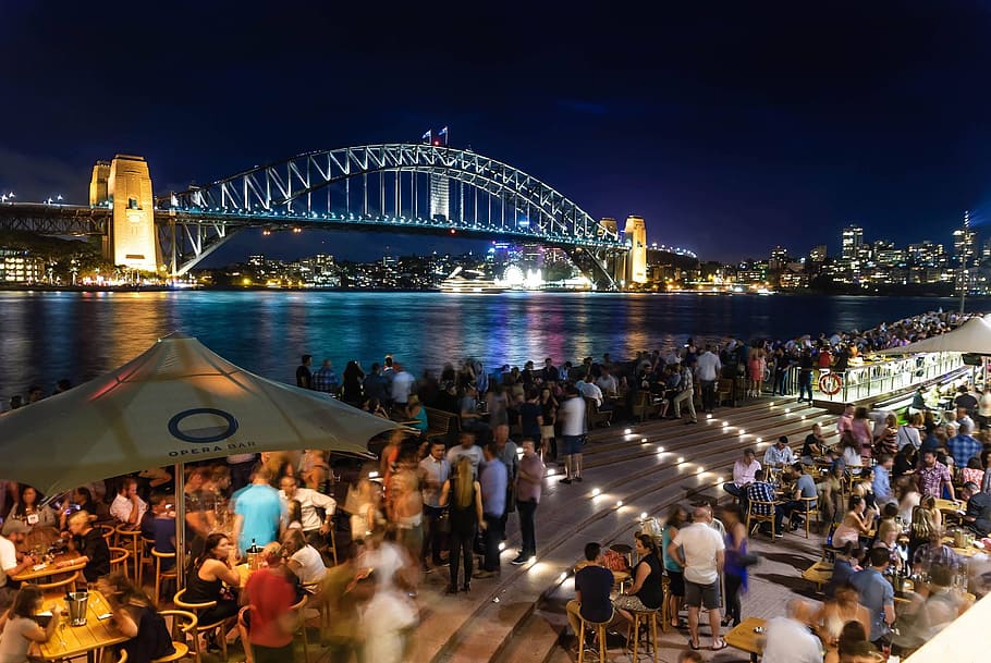 People Sitting and Standing Near Bridge during Nighttime, architecture