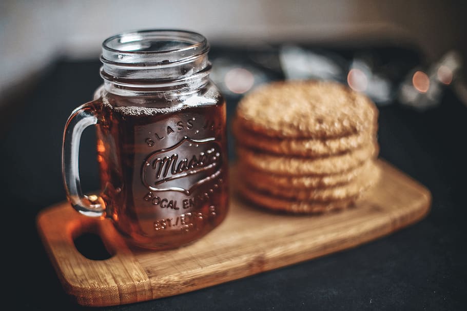 clear glass mason jar beside cookies on brown wooden tray, food