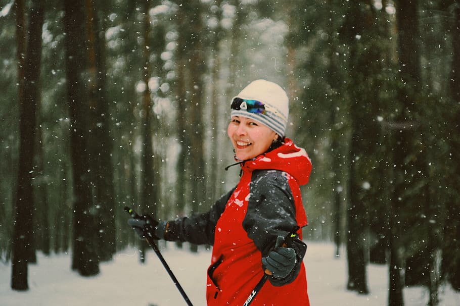 smiling woman ice skiing during snowy daytime, vest, apparel