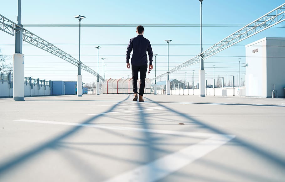 man standing on gray surface near metal frames, walking, person, HD wallpaper