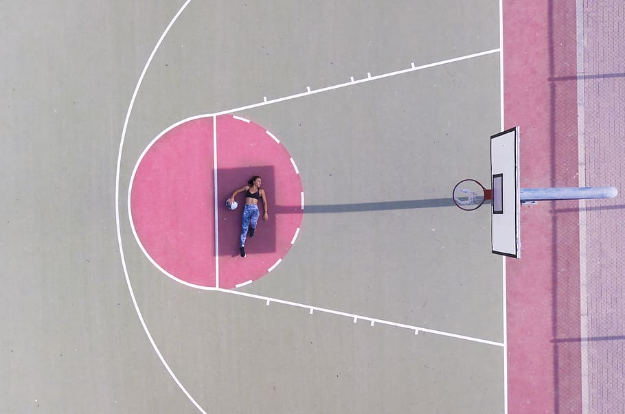 Woman Lying on Basketball Free Throw Line, aerial shot, basketball court