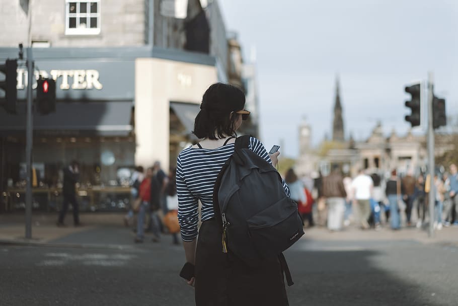 woman wearing striped shirt holding phone on side of street, woamn HD wallpaper