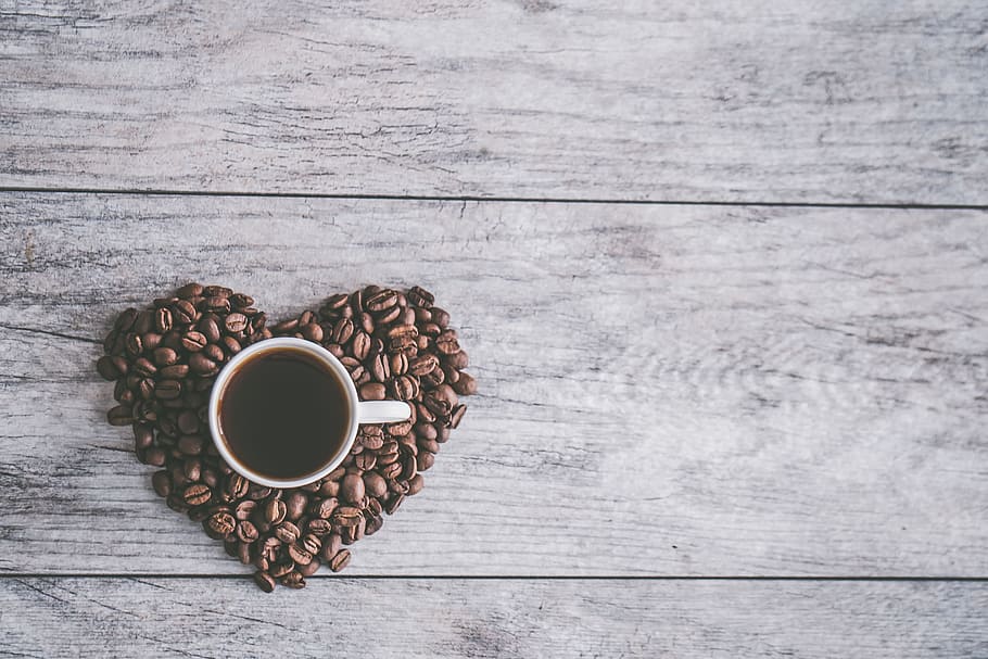 White Ceramic Mug Filled With Brown Liquid on Heart-shaped Coffee Beans HD wallpaper