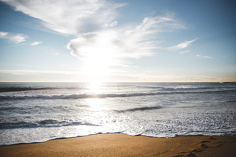 Sunrise over a Barcelona beach with waves approaching the shore HD wallpaper