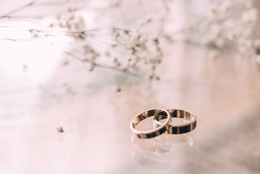 Two Silver-colored Rings on Beige Surface, blurred background