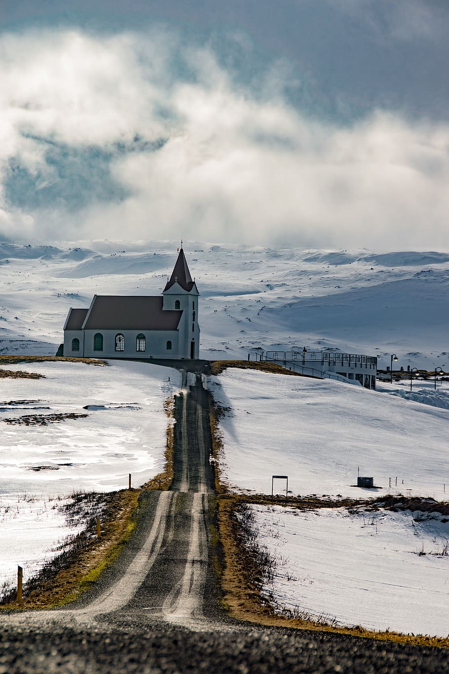 Black Concrete Road Between Snow Covered Ground Near White and Brown Chapel HD wallpaper