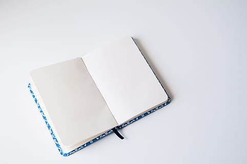 opened book on white platform, clean, minimal, notes, writing HD wallpaper