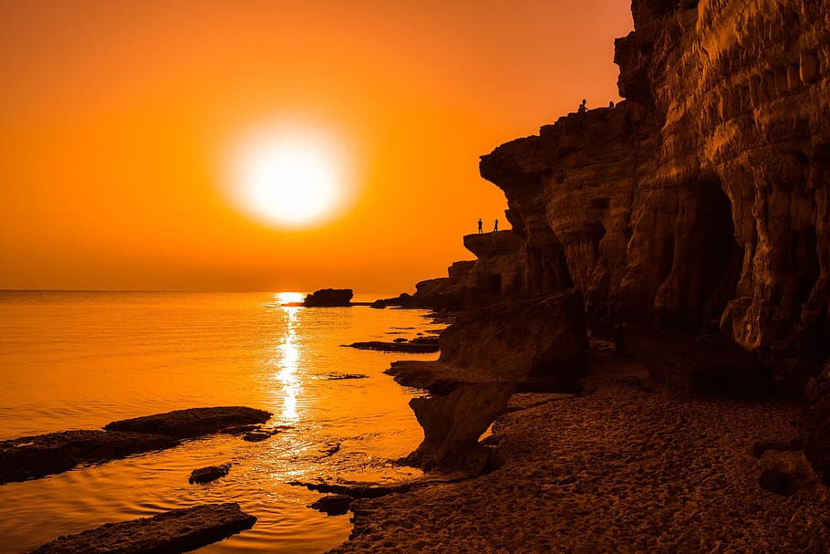 sunset, dusk, sea, water, rock, cliff, shadows, landscape, orange HD wallpaper