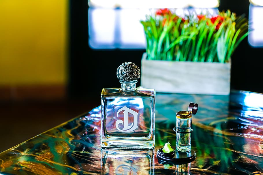 Clear Glass Perfume Bottle on Table, blurred background, close-up HD wallpaper