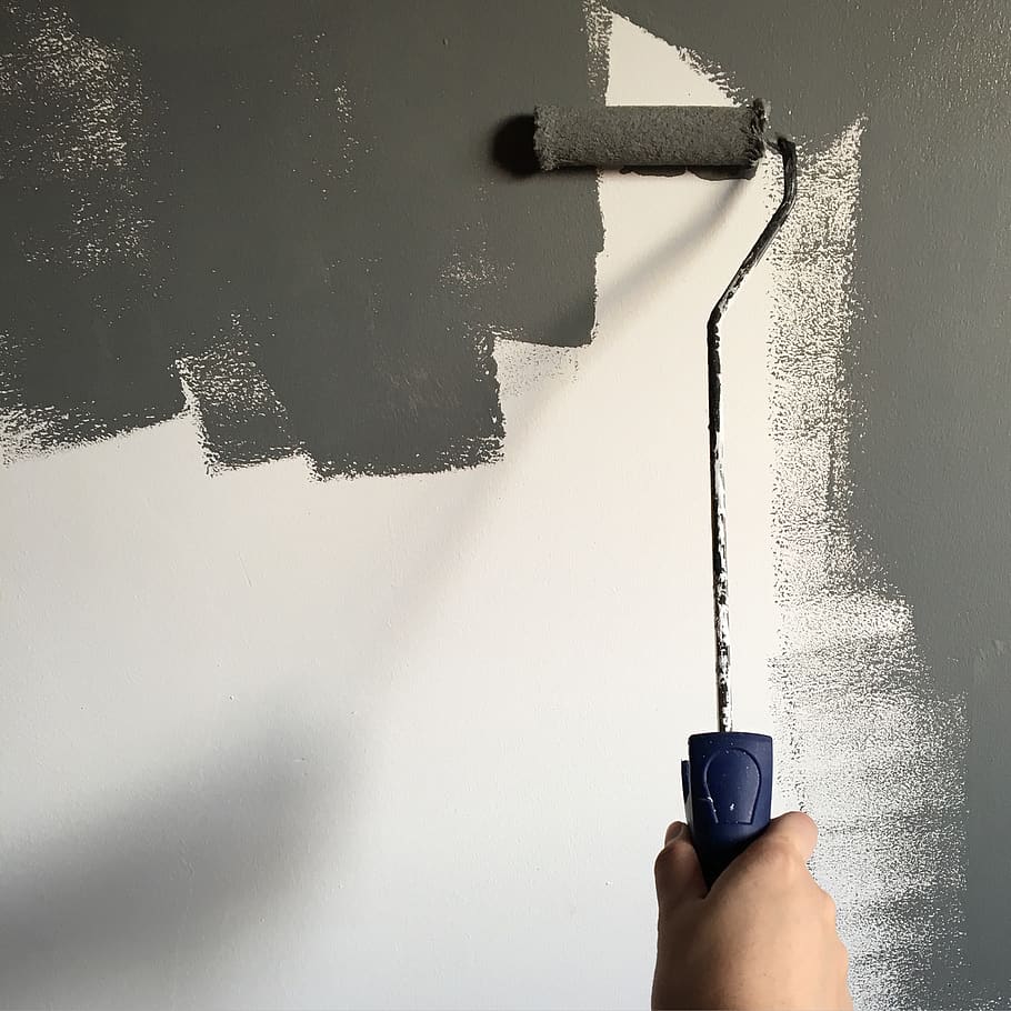Person Holding Paint Roller While Painting the Wall, daylight HD wallpaper