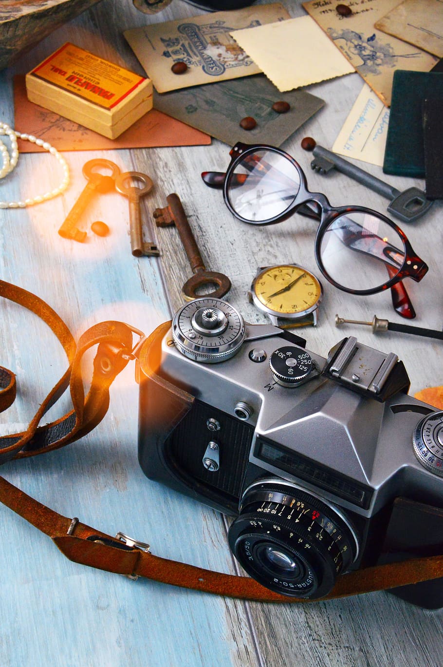 Black and Gray Camera, Skeleton Keys, and Brown Framed Eyeglasses on Gray Surface HD wallpaper