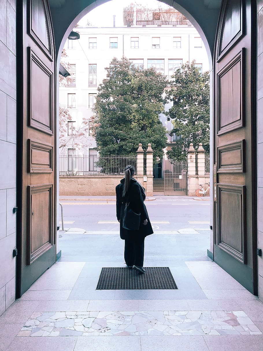 Photo of Woman In Black Outfit Standing Near Big Brown Opened Door HD wallpaper