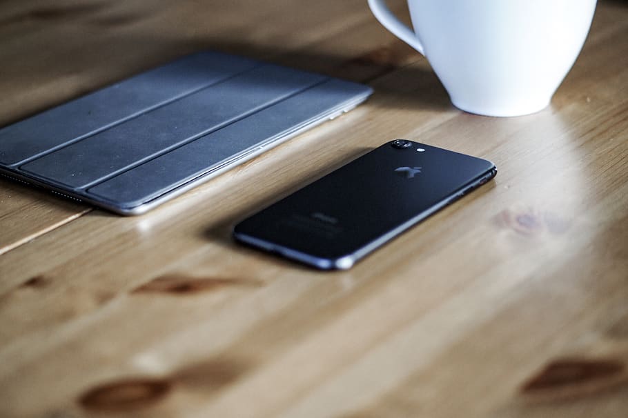 black iPhone 7 on brown surface, technology, wireless technology HD wallpaper