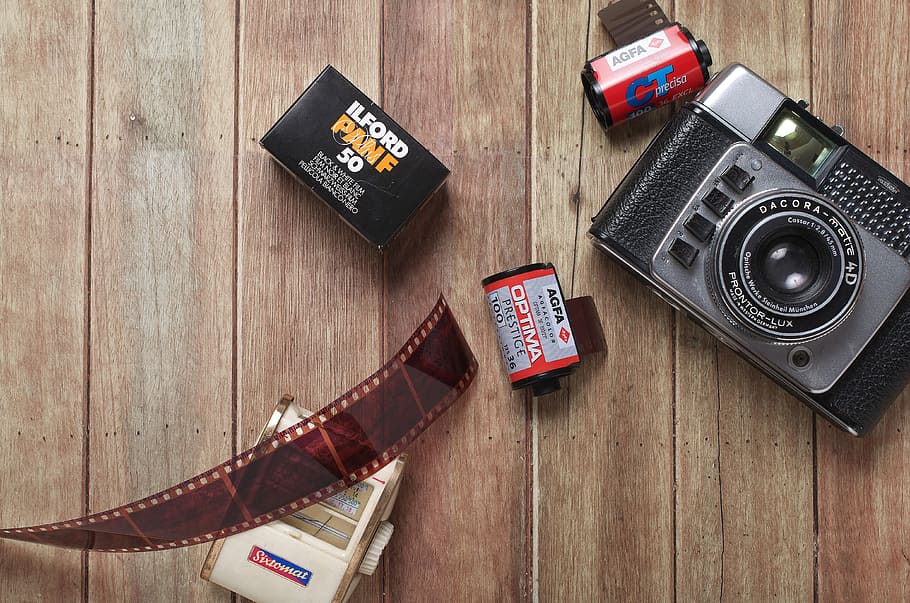 flat lay photography of film camera and films on wood parquet HD wallpaper