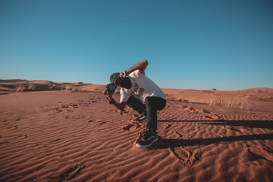 man almost sitting and using DSLR camera, soil, person, human HD wallpaper