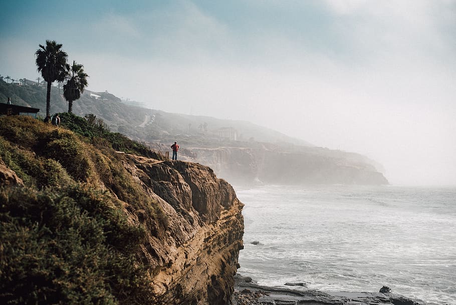 cliff, cliffs, ocean, sea, person, human, mist, fog, sun, sky HD wallpaper