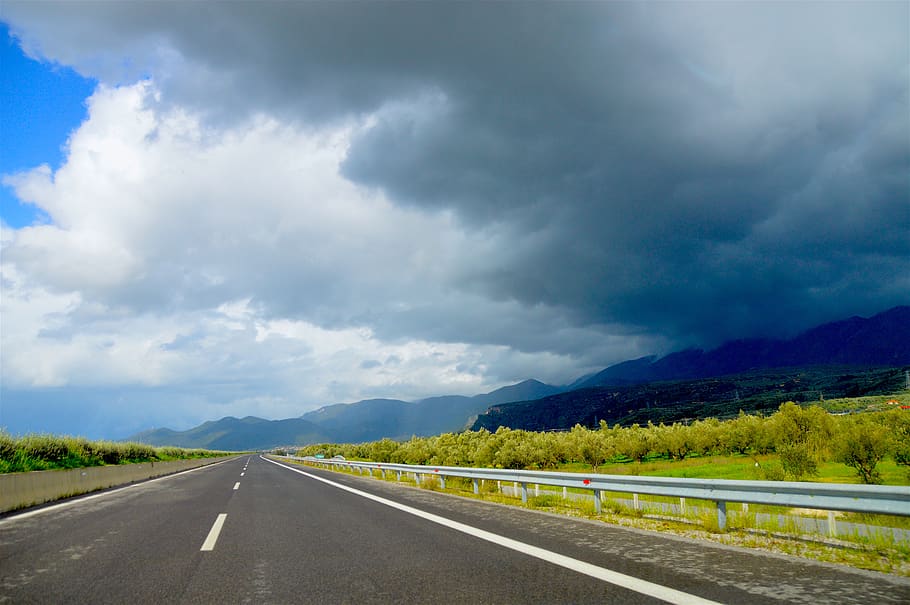 Photo of Road Near Green Leaf Trees Under Dark Clouds at Daytime HD wallpaper