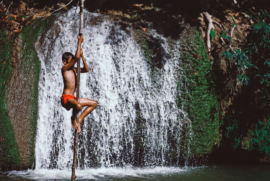 Boy Climbing Stick Beside Waterwalls, child, daylight, daytime HD wallpaper