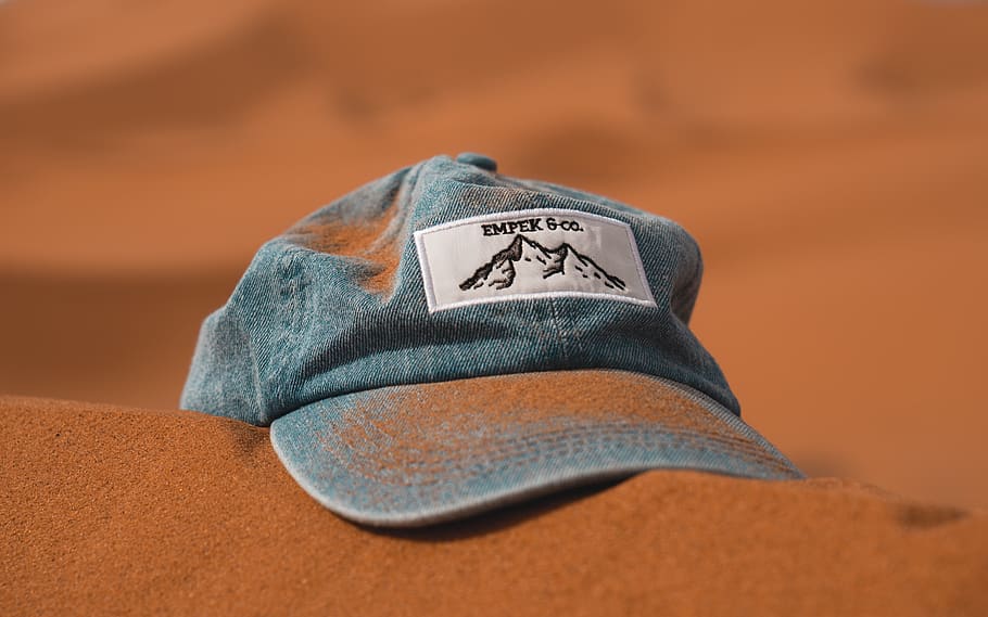blue cap on brown sand, text, casual clothing, indoors, no people HD wallpaper