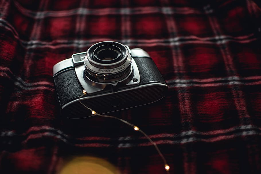 Black and Gray Point-and-shoot Camera on Red, Black, and White Plaid Textile HD wallpaper