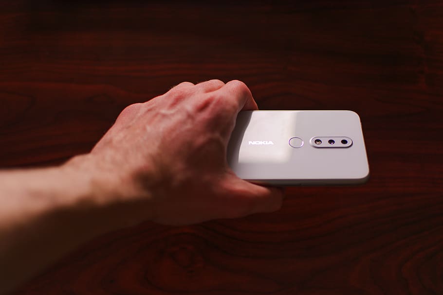 person holding silver smartphone, human hand, technology, human body part HD wallpaper