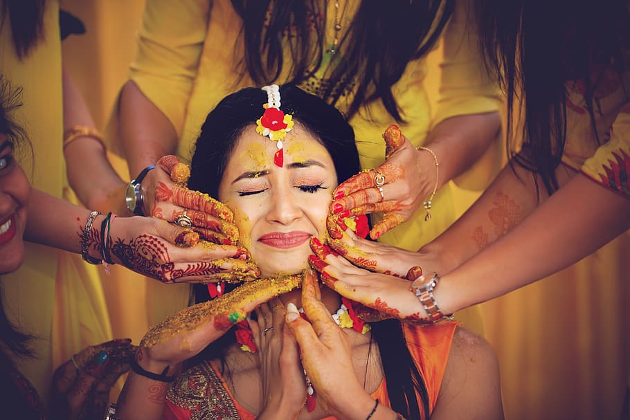 Women in Yellow Dresses Surrounding and Putting Paint on Woman's Face