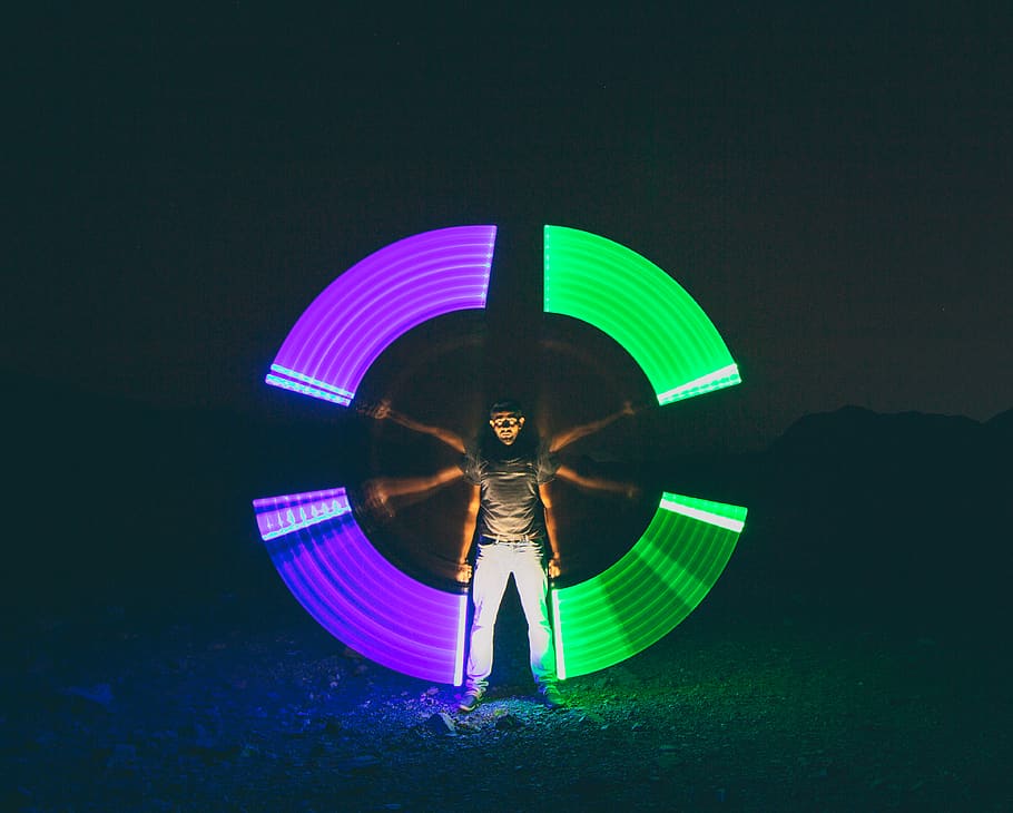 Time Lapse Photography of Man Holding Purple and Green Light Fixtures HD wallpaper