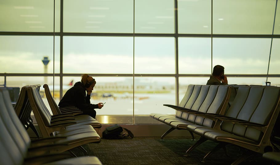 man and woman sitting on gang chair in airport, human, person