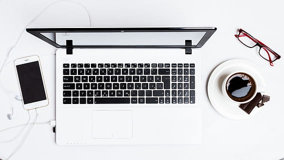 MacBook Pro between smartphone and teacup on white surface, computer HD wallpaper