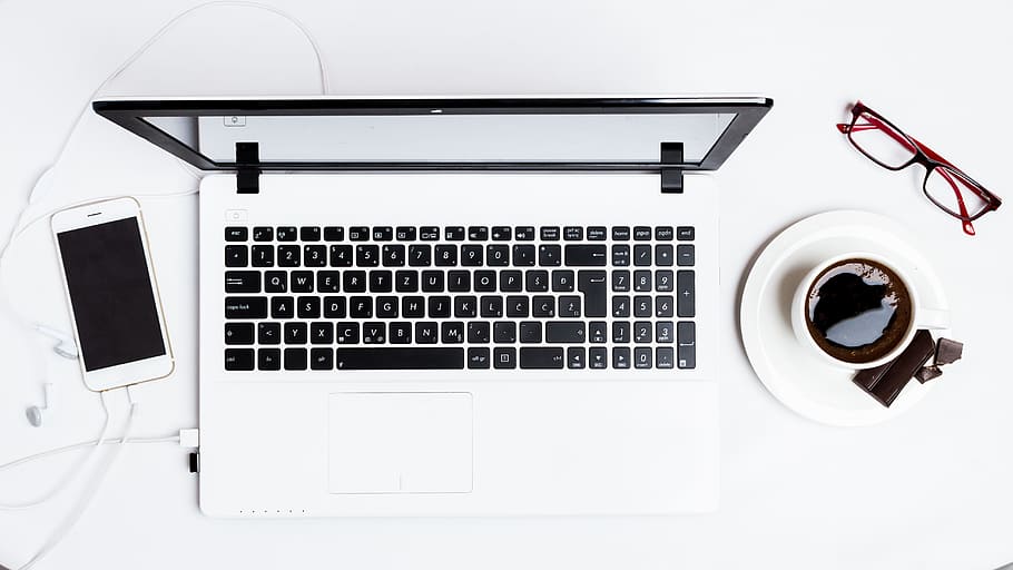 MacBook Pro between smartphone and teacup on white surface, computer HD wallpaper