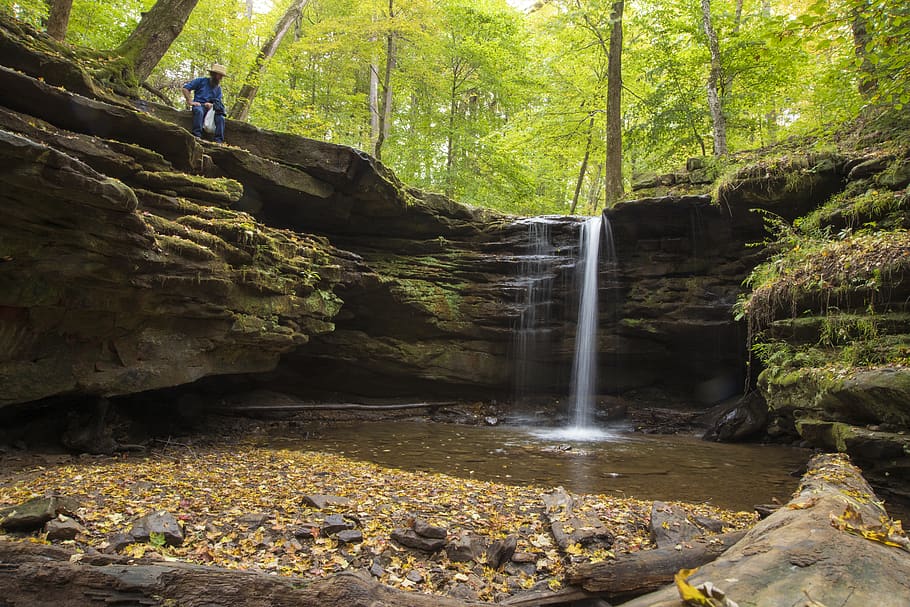man sitting on rock formation, stream, water, creek, outdoors HD wallpaper