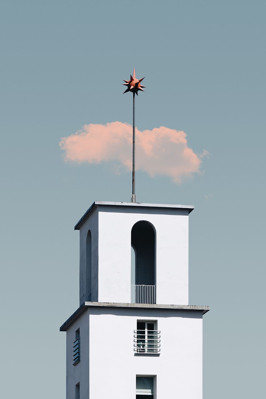 white concrete tower with star-like topper under cloudy blue sky HD wallpaper