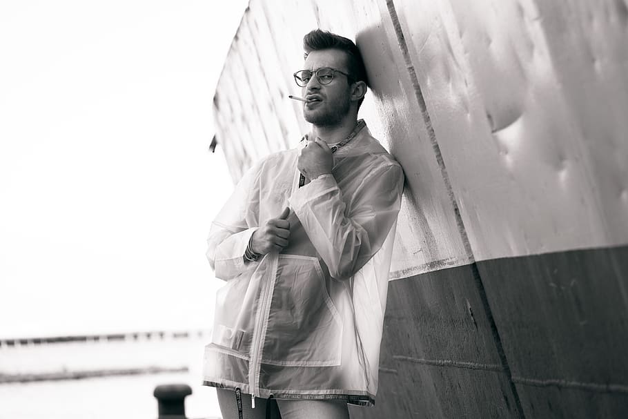 grayscale photography of man leaning on wall, clothing, apparel