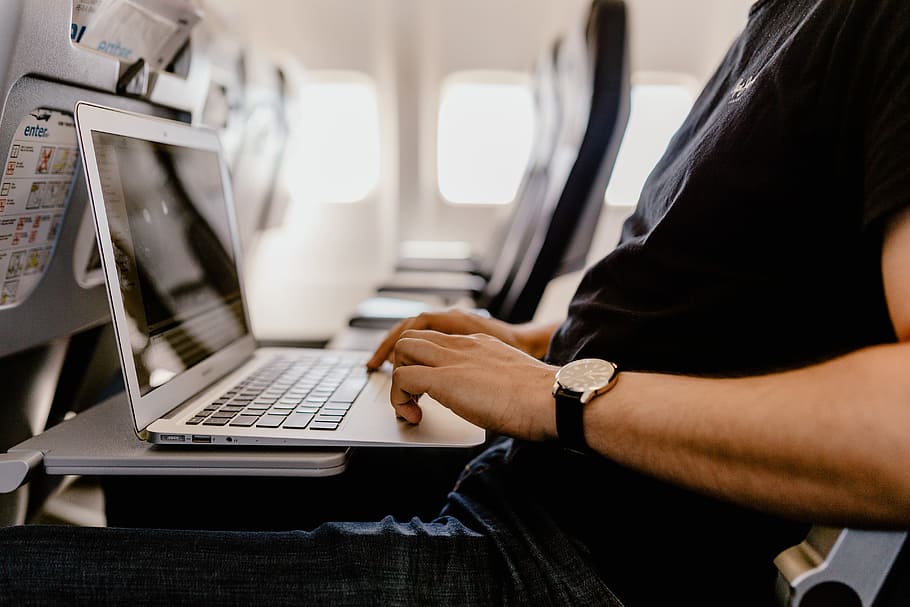 Unrecognizable man with notebook sitting inside an airplane, adult HD wallpaper