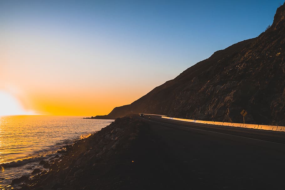 ocean, sea, sun, sunset, orange, blue, sky, mountain, road HD wallpaper