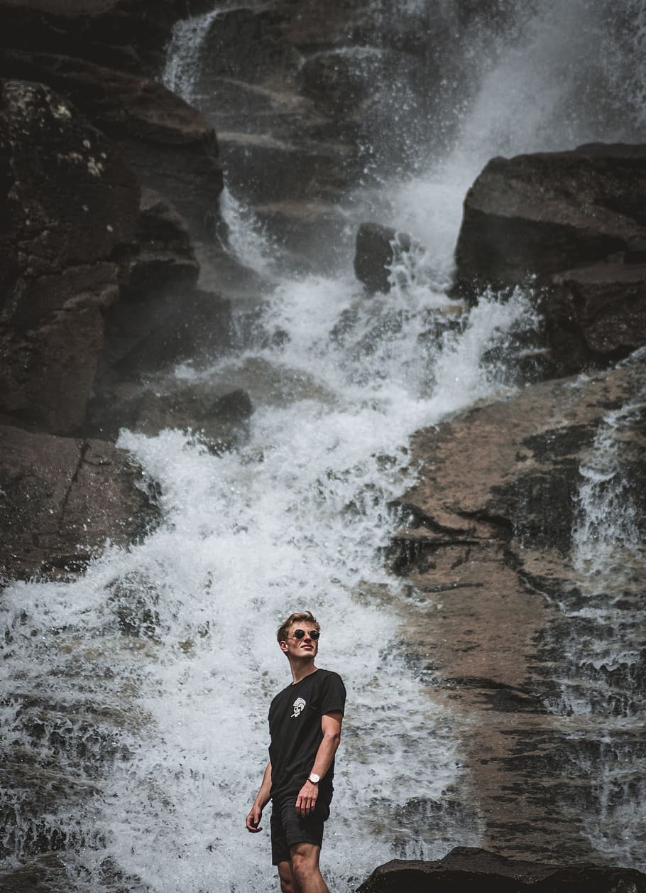 man standing in front of waterfalls, portrait, explore, adventure HD wallpaper