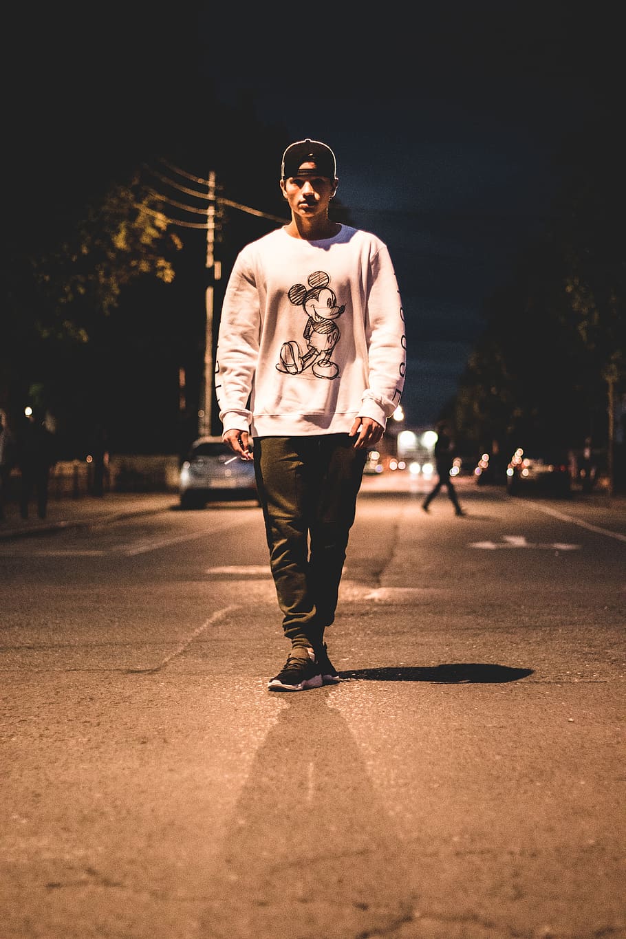 man standing in the middle of road during nighttime, person, human